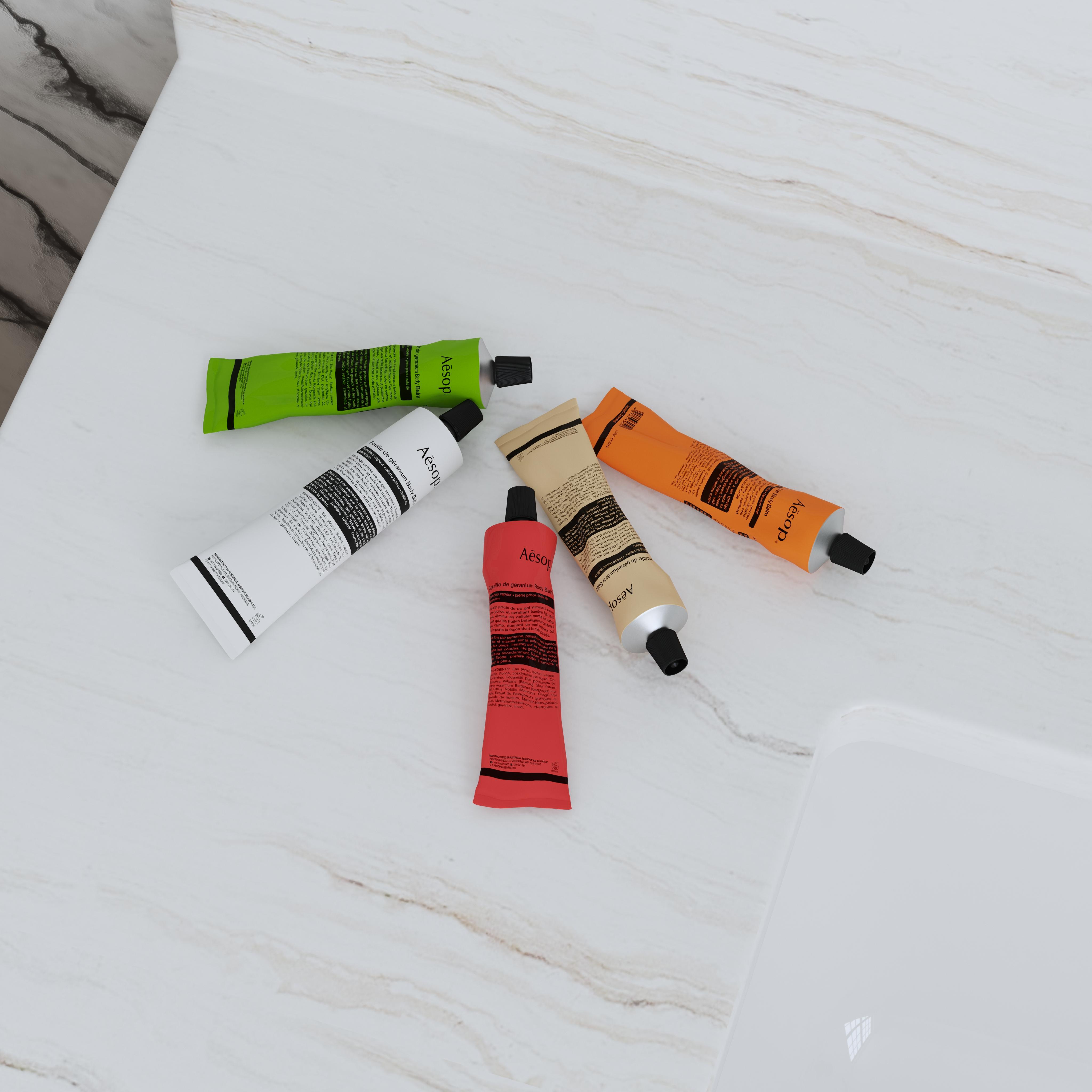 Five colorful skincare tubes arranged as a coordinated product collection on a light marble surface